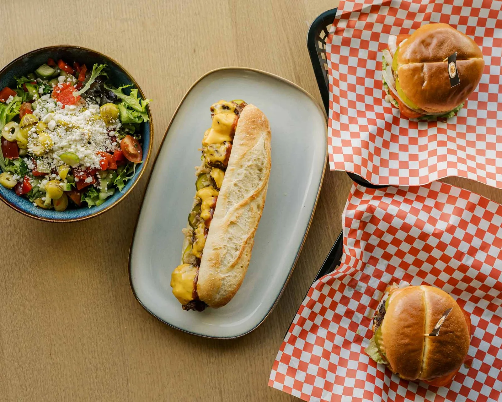 The Hungry Odin's food spread with a meatball sandwich, salad and burgers