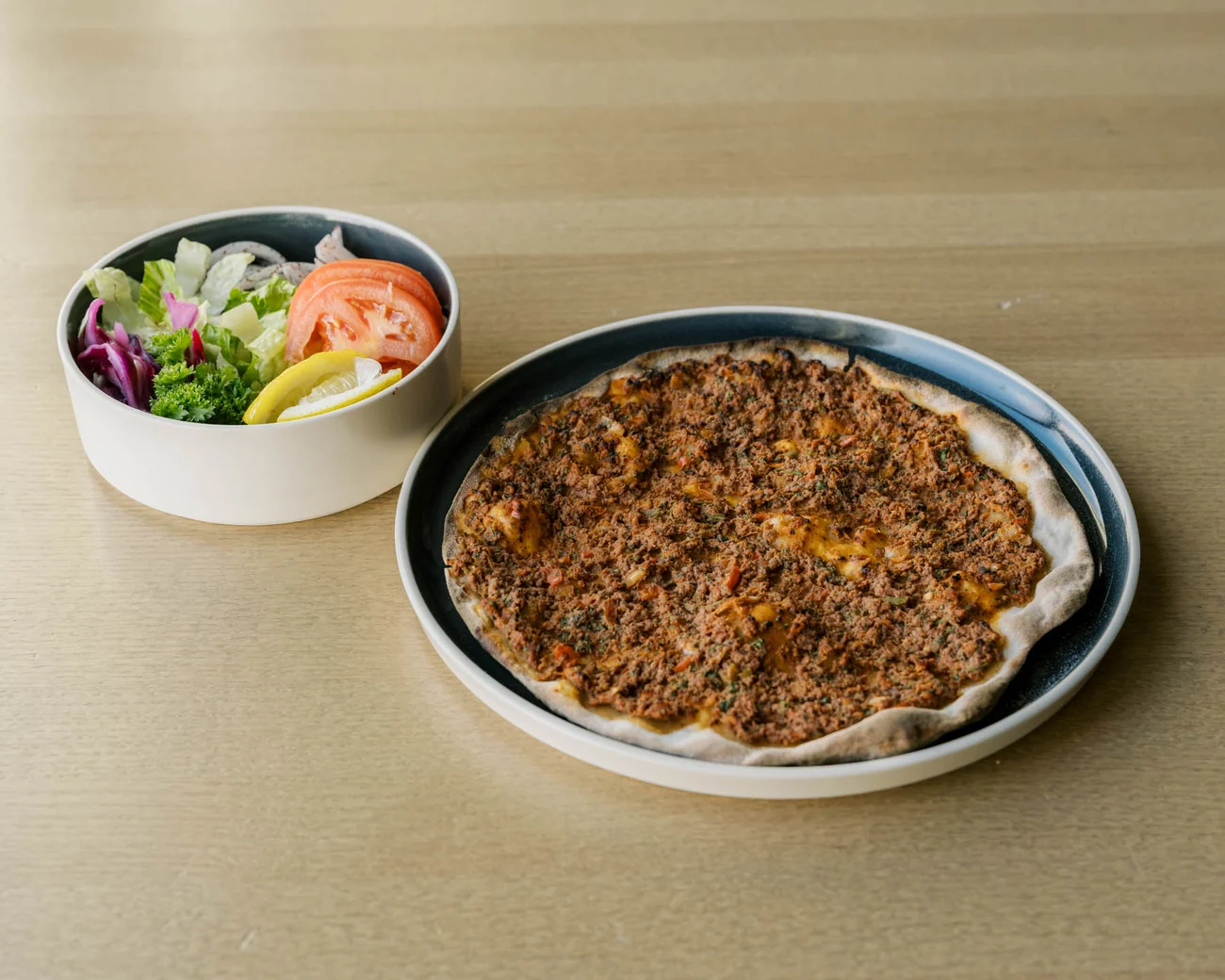 The Hungry Odin lahmacun served with fresh greens, tomato and lemon